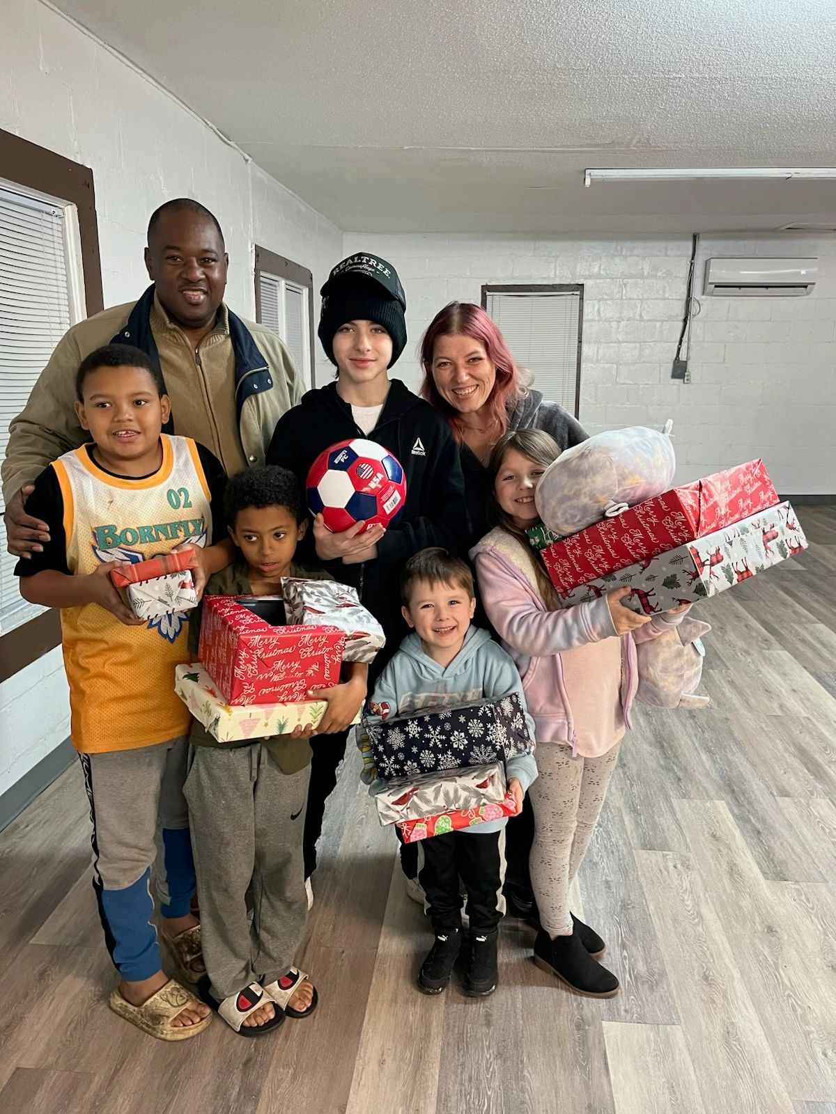 A family holding wrapped Christmas gifts at the Hampton County Sheriff's Office Santa's Wonderland toy drive.