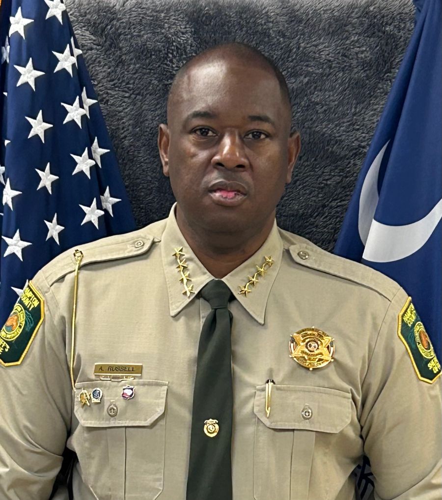 Portrait of Sheriff Anthony 'Bubba' Russell in uniform, standing in front of the American and South Carolina flags